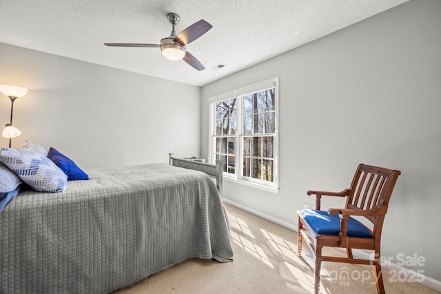 bedroom with light carpet, a textured ceiling, visible vents, and baseboards