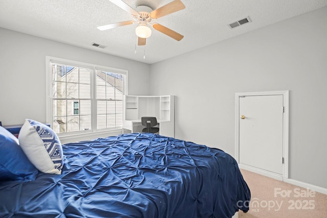 bedroom with a ceiling fan, carpet, visible vents, and a textured ceiling