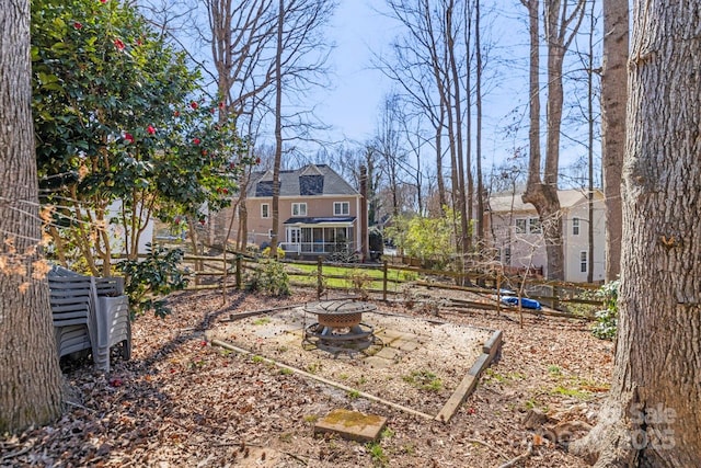 view of yard with fence and a fire pit