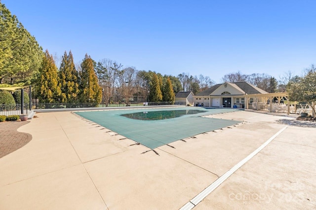 pool with a patio area and fence