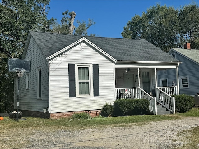 bungalow featuring a porch and roof with shingles