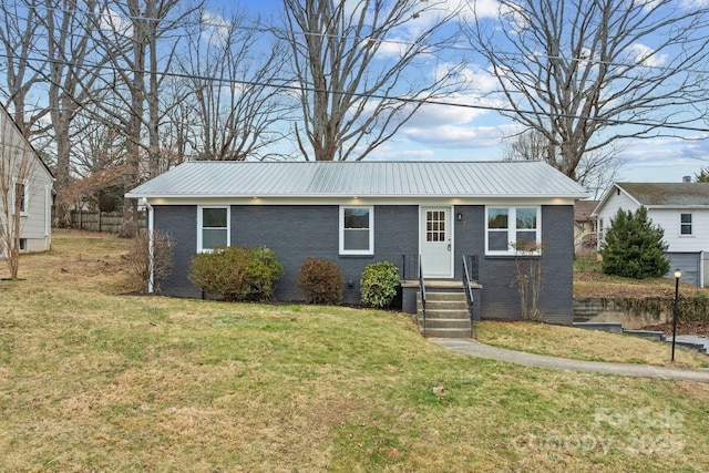 ranch-style house with metal roof, brick siding, and a front yard