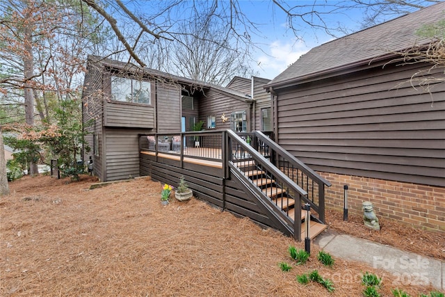 view of home's exterior with a deck and roof with shingles