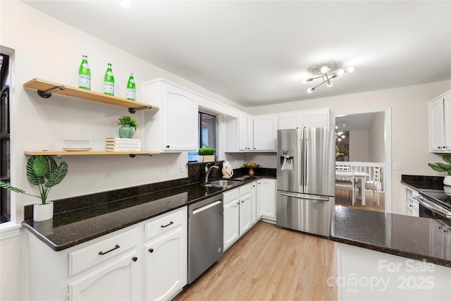 kitchen with appliances with stainless steel finishes, white cabinetry, and open shelves