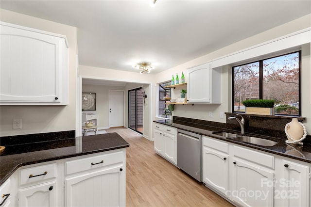 kitchen featuring open shelves, light wood-style floors, white cabinets, a sink, and dishwasher