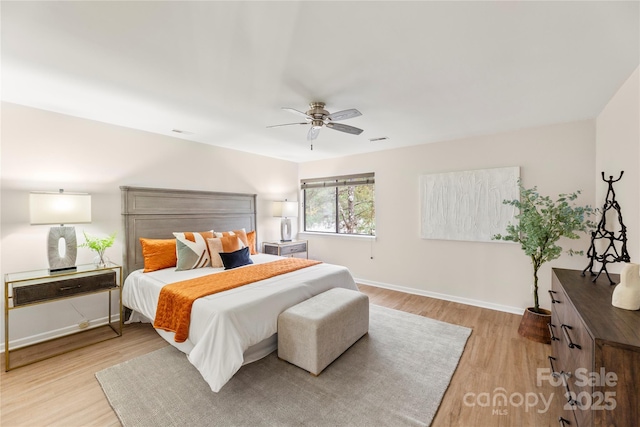 bedroom with ceiling fan, light wood-type flooring, visible vents, and baseboards