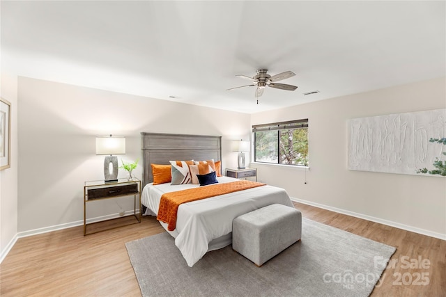 bedroom featuring visible vents, ceiling fan, light wood-style flooring, and baseboards