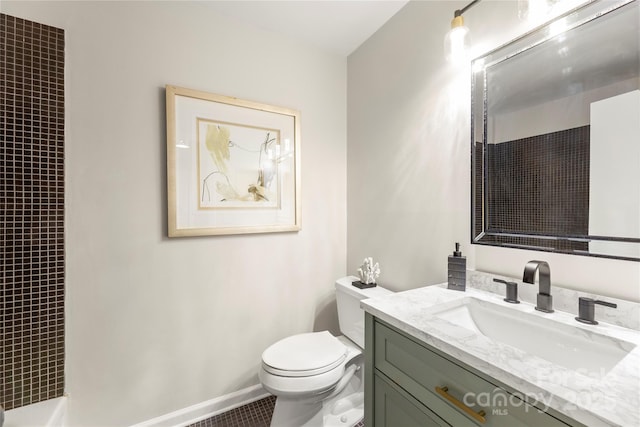 full bathroom with baseboards, vanity, and toilet