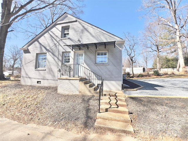 bungalow-style house featuring crawl space and brick siding