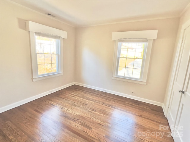 spare room with plenty of natural light, dark wood finished floors, and baseboards