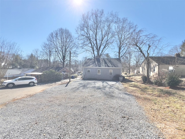 view of front of home with a residential view and gravel driveway