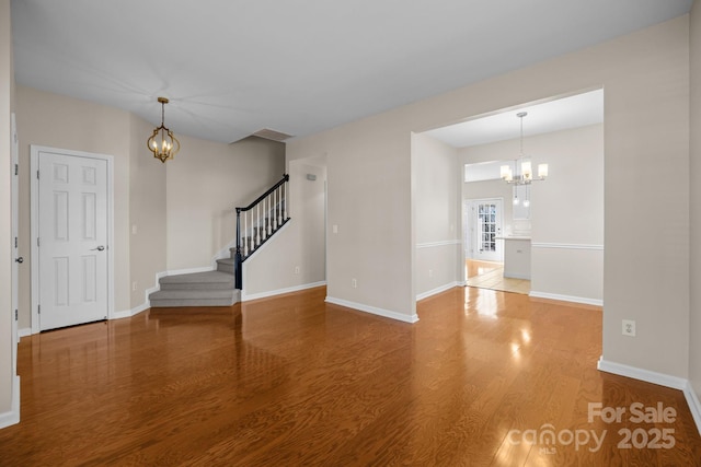 interior space with a notable chandelier, stairway, baseboards, and wood finished floors