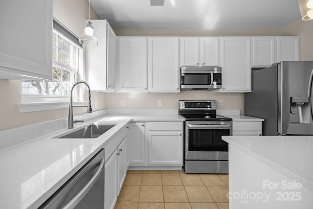 kitchen featuring appliances with stainless steel finishes, light countertops, white cabinets, and a sink
