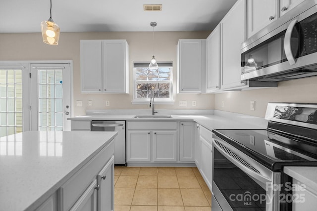 kitchen featuring visible vents, appliances with stainless steel finishes, light countertops, and a sink