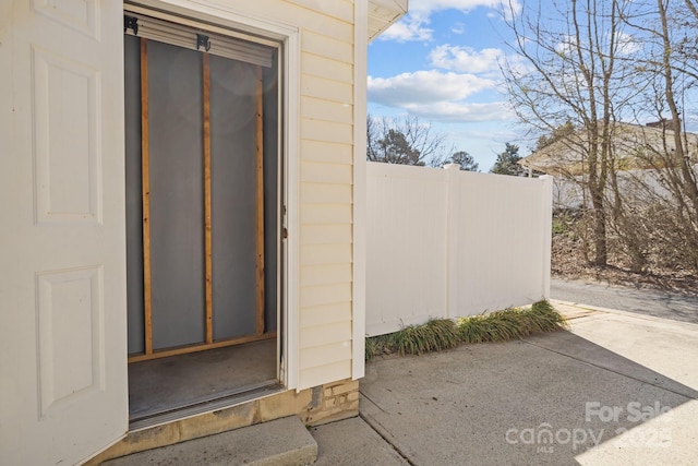 property entrance with a patio and fence