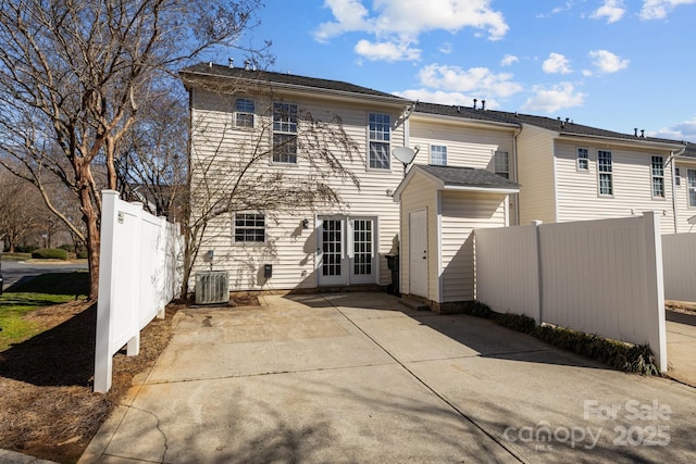 back of property featuring cooling unit, french doors, fence, and a patio