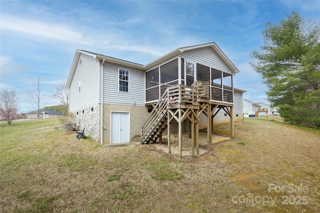 rear view of house with a sunroom, stairs, and a lawn