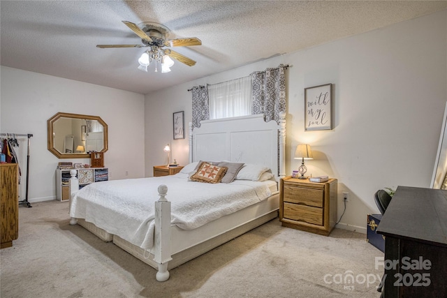 carpeted bedroom featuring baseboards, a ceiling fan, and a textured ceiling