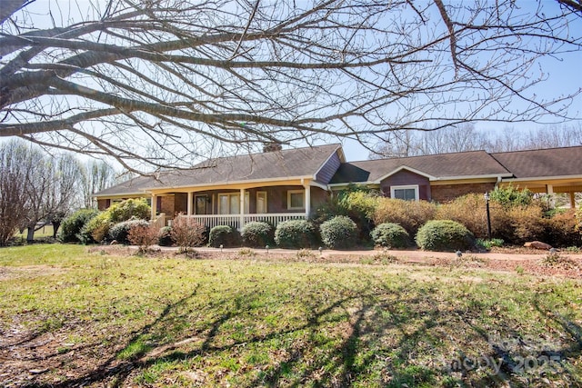 ranch-style house featuring brick siding, covered porch, and a front lawn