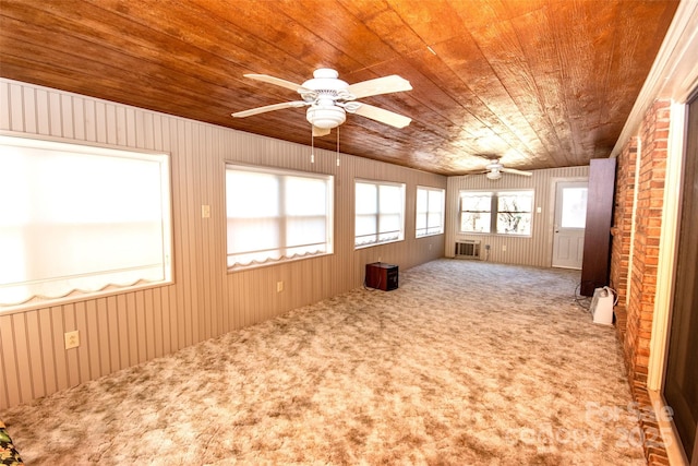 spare room with a wall mounted air conditioner, carpet floors, wood ceiling, and a ceiling fan