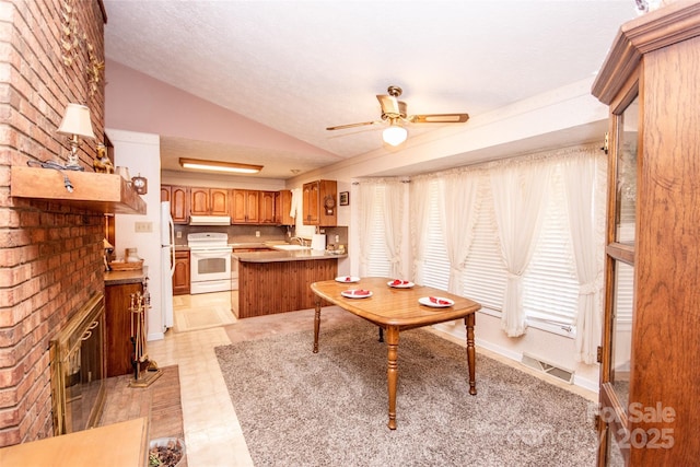 interior space with under cabinet range hood, lofted ceiling, a peninsula, a fireplace, and white electric range oven