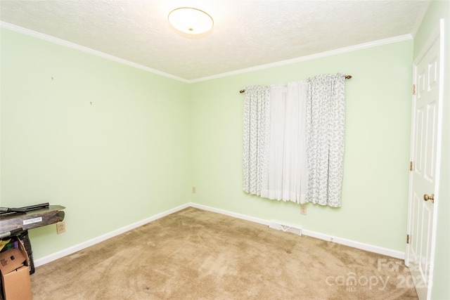 unfurnished room featuring carpet flooring, a textured ceiling, crown molding, and baseboards