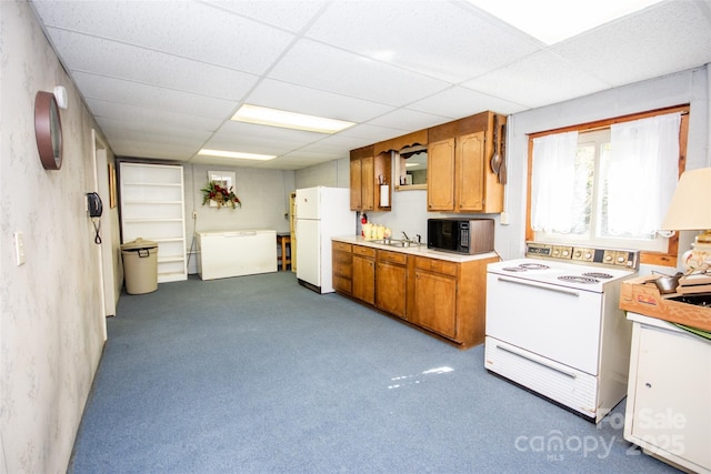 kitchen featuring a paneled ceiling, white appliances, brown cabinetry, and light countertops