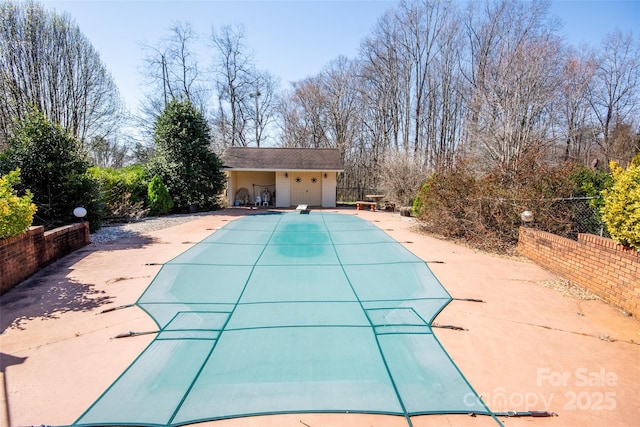 view of swimming pool featuring a diving board, a fenced in pool, fence, and a patio area