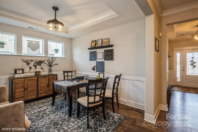 dining area featuring a wealth of natural light, a raised ceiling, visible vents, and dark wood-style flooring