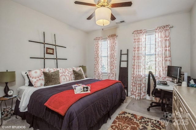 bedroom with light carpet, visible vents, and a ceiling fan