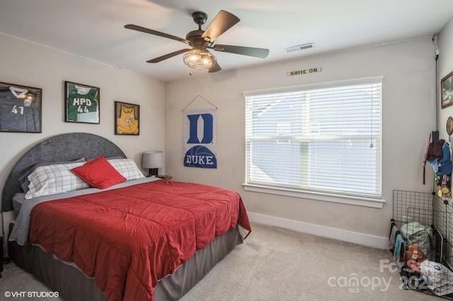 bedroom featuring light colored carpet, ceiling fan, visible vents, and baseboards