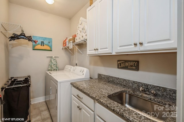 washroom featuring cabinet space, washing machine and dryer, baseboards, and a sink