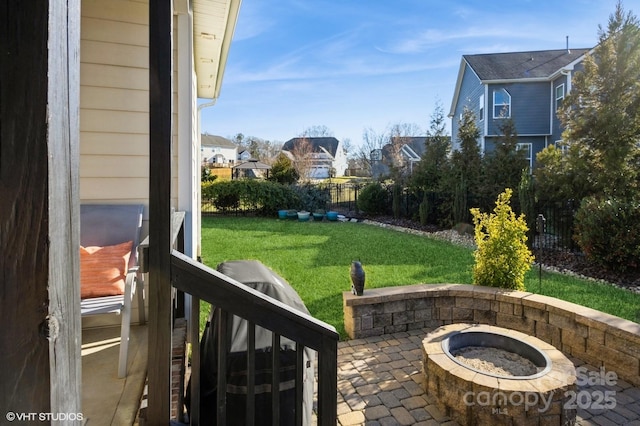 exterior space with a patio, an outdoor fire pit, fence, and a residential view