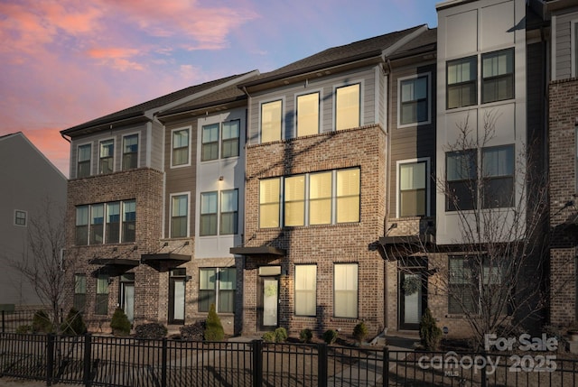 property at dusk with a fenced front yard