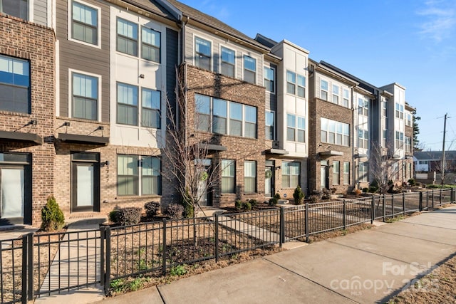 view of building exterior featuring a residential view and a fenced front yard