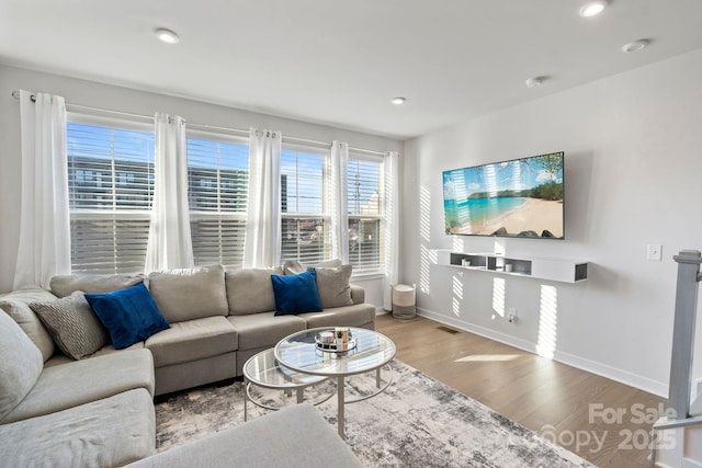 living room featuring visible vents, recessed lighting, baseboards, and wood finished floors