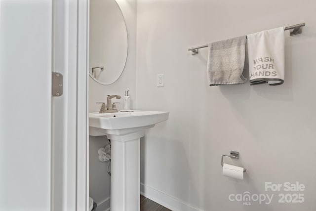 bathroom featuring baseboards and a sink