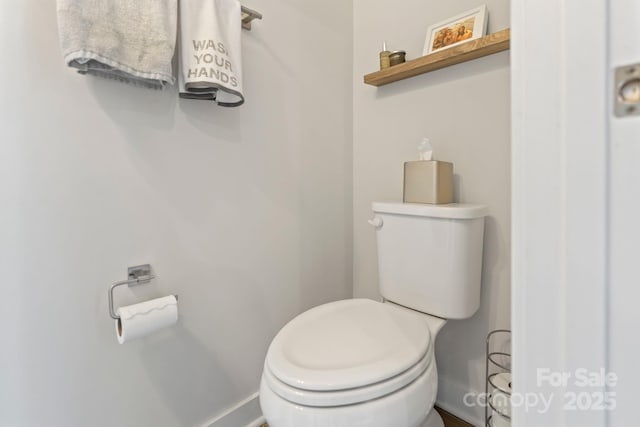 bathroom featuring baseboards and toilet