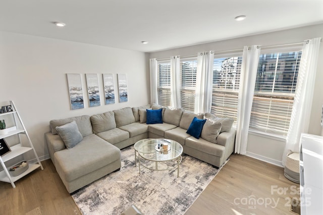 living area with recessed lighting, baseboards, and wood finished floors