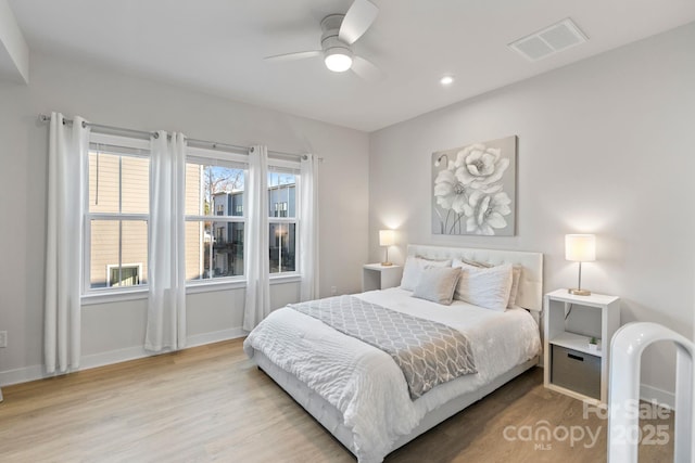 bedroom featuring visible vents, baseboards, and wood finished floors