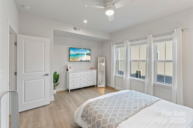 bedroom featuring light wood-type flooring, visible vents, baseboards, and ceiling fan