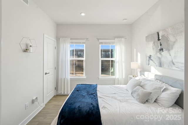 bedroom featuring baseboards and wood finished floors