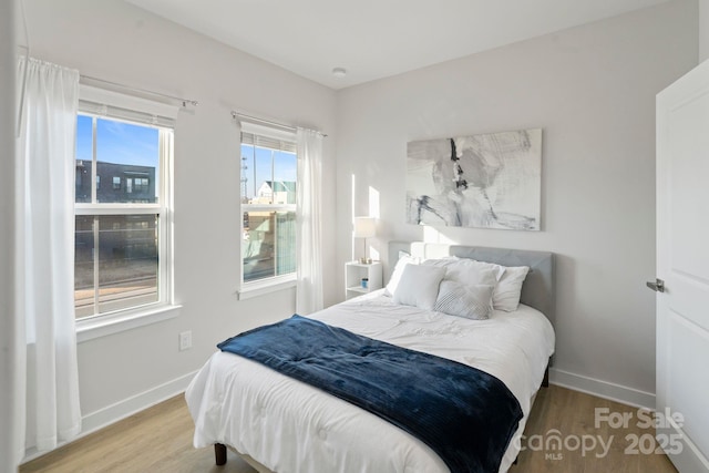 bedroom with wood finished floors and baseboards