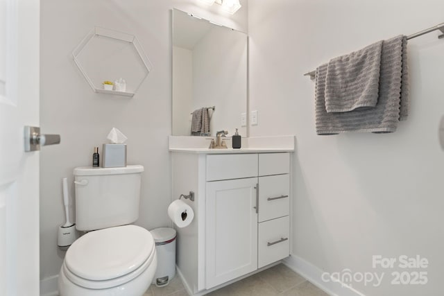 half bath featuring tile patterned floors, toilet, vanity, and baseboards