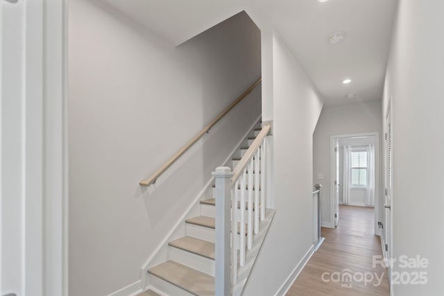 stairway with baseboards and wood finished floors