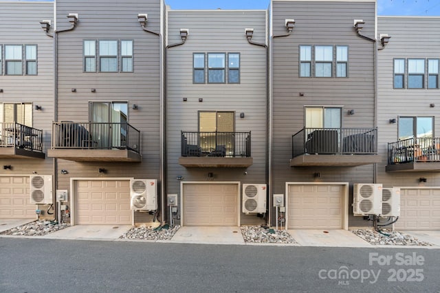 rear view of house with an attached garage and ac unit