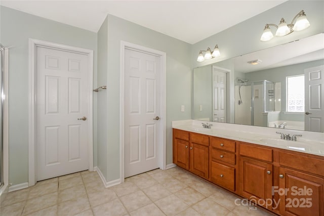 full bathroom featuring a sink, double vanity, a shower stall, and tile patterned floors