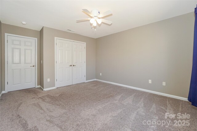 unfurnished bedroom with visible vents, a closet, carpet, baseboards, and ceiling fan