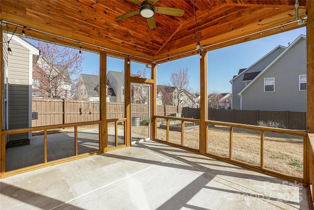 unfurnished sunroom with a wealth of natural light, a residential view, a ceiling fan, and lofted ceiling