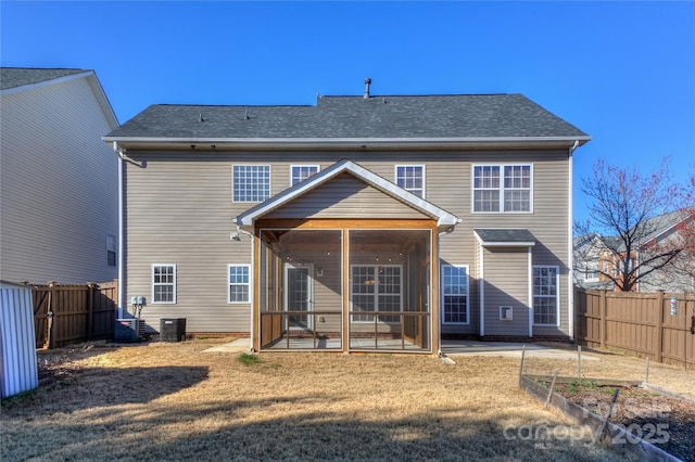 rear view of house featuring central air condition unit, a sunroom, a lawn, a fenced backyard, and a garden